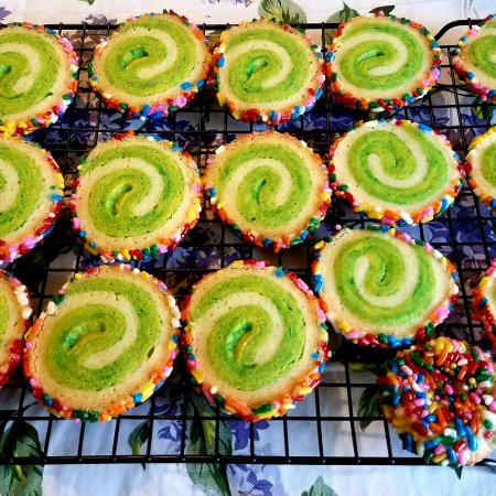 White and green pinwheel cookies with rainbow sprinkles around the edges.